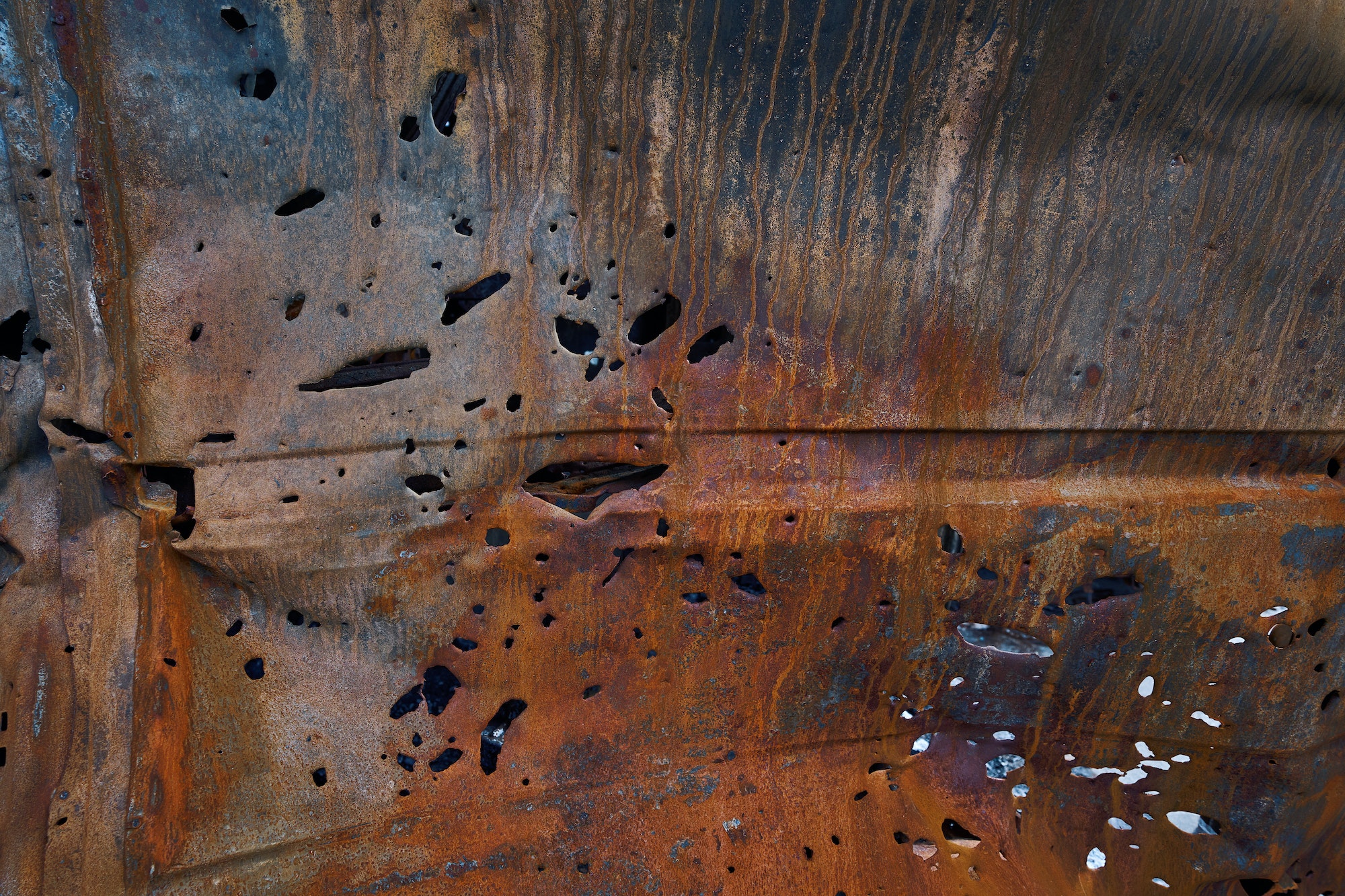 Bullet and shrapnel holes in carcass of destroyed car