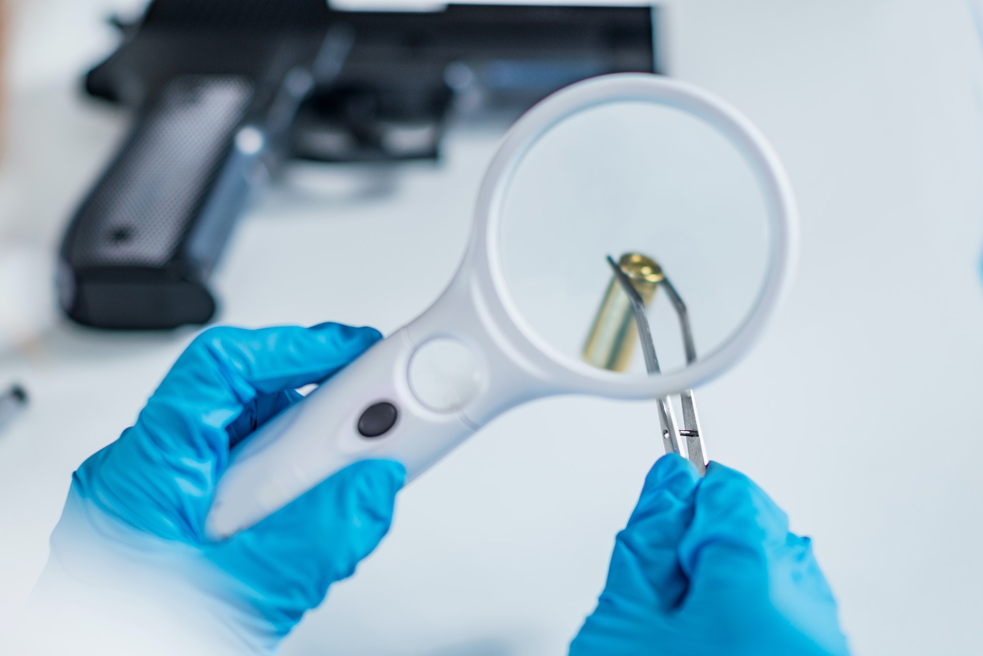 Forensic scientist examining bullet casing